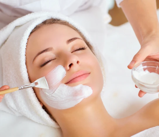 A smiling guest relaxing during a facial treatment